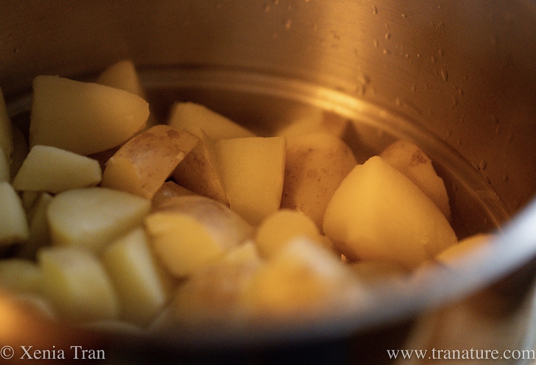 close up of cubed organic potato in a steam pan